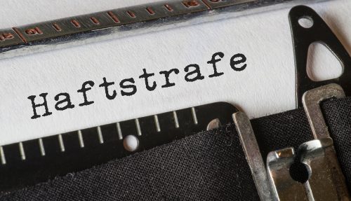 Das Wort 'Haftstrafe', getippt mit einer Vintage-Schreibmaschine. Illustration der rechtlichen Konsequenzen bei Stalking und der Beharrlichkeitsprüfung nach dem BGH-Beschluss zur Nachstellung (§ 238 StGB).